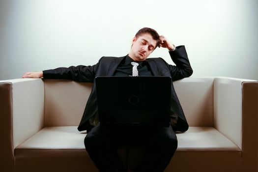 Businessman on lounge holding a laptop