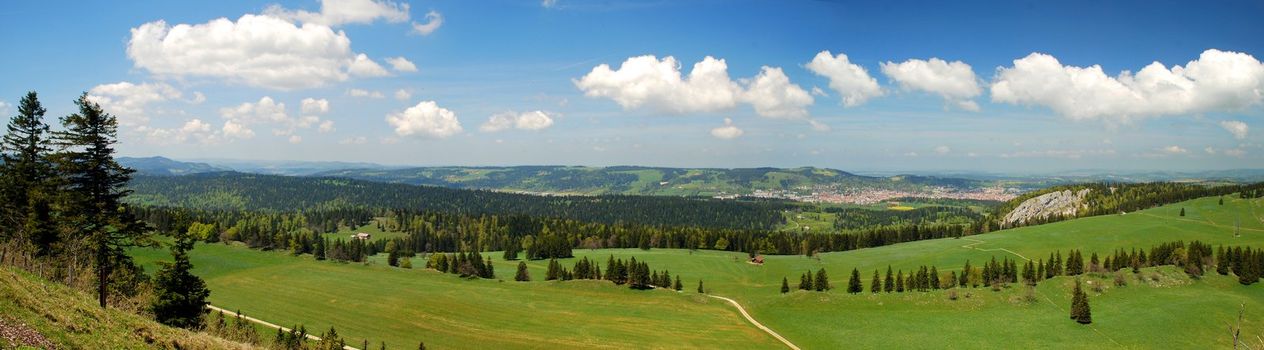 It is a part of most beutyful panoramas of Switzerland Jura, seen from Tete-de-Run hill, Chaux-de-Fonds town seen at right, Jura woods cover hills and in the plane  there are fields and farms, France is in this dirrection, already visible along the horizont 