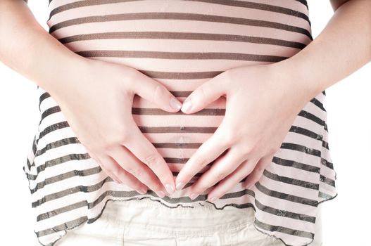Pregnant woman holding her hands in form of heart sign on her belly