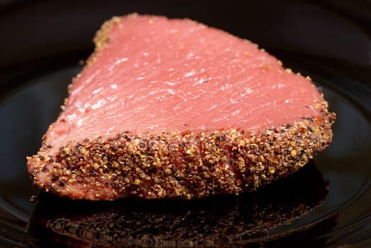 A fresh, raw beef steak with a pepper crust