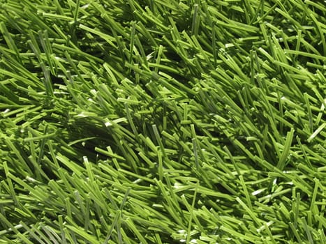 Detail of green grass artificial lawn meadow, useful as a background