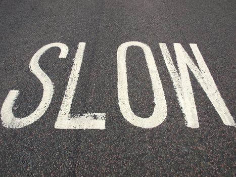 Slow warning sign painted on a street