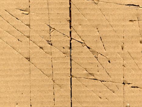 Brown torn corrugated cardboard sheet background with cuts