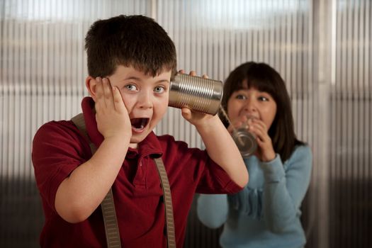 Little boy getting shocking message from girl on tin can phone