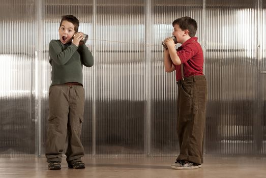 Little boy getting shocking message from friend on tin can phone