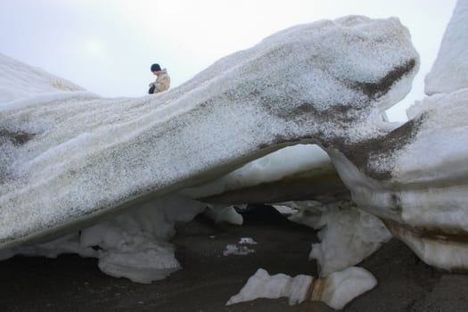 Person walking inside the large ice chunks of Arctic Ocean shore 