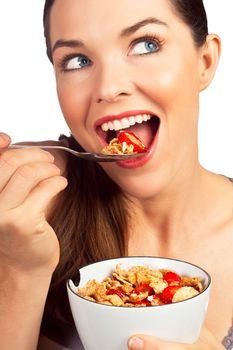 A close-up portrait of a beautiful young woman eating a healthy bowl of cereal with strawberries. Isolated over white.