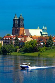 Cathedral church and motorboat at the river in the center of city
