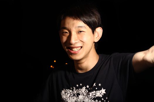Asian Man smile in black background.