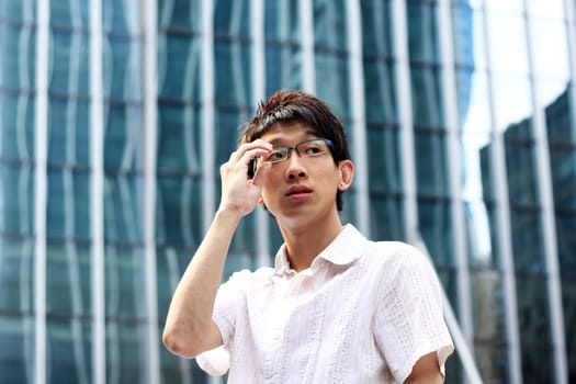 asian businessman holding glasses and modern building 