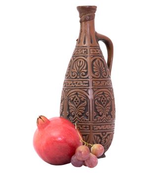 Still-life with a bottle and pomegranate on a white background