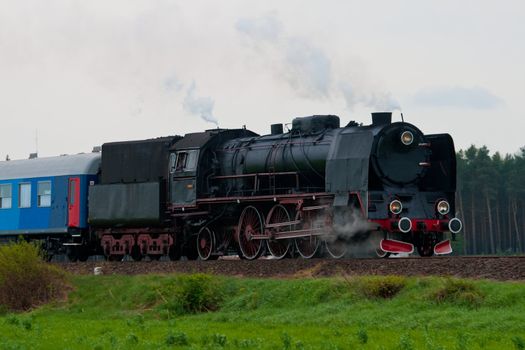 Old retro steam train passing through polish countryside
