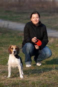 Girl with a tri colored beagle in a park
