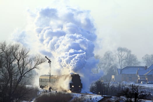 Vintage steam train starting from the station during wintertime