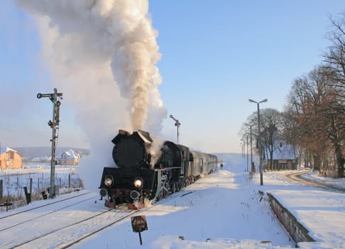 Vintage steam train starting from the station, wintertime