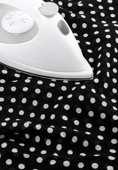 Ironing delicate black and white silky fabric.