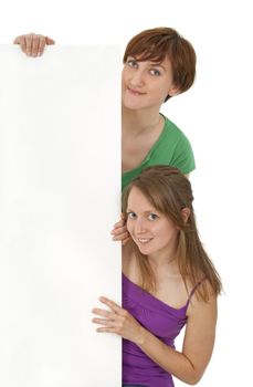 Two friendly young women in colorful clothes holding a blank banner ad.