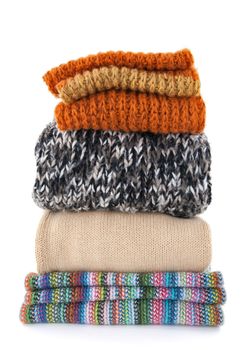 Pile of warm wool clothes on white background.