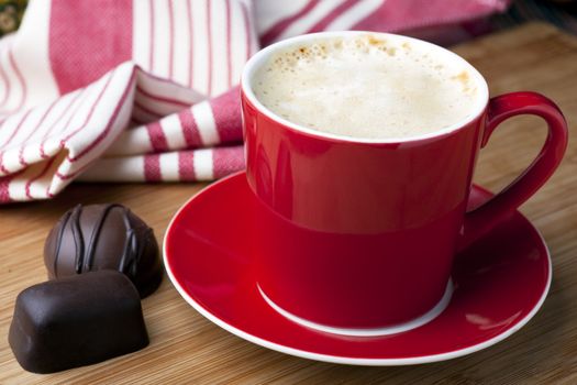 Fresh latte and two gourmet chocolates for a well deserved break.