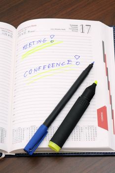 Diary with notes and a marker pen on wooden table
