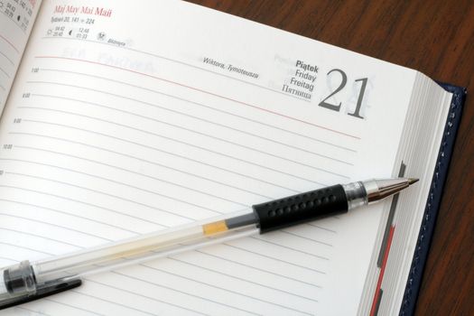 Diary and a pen on wooden table