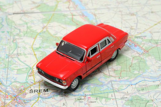 Tiny red car model on the road map