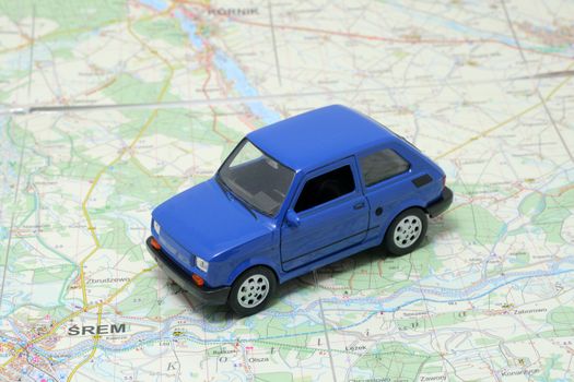 Tiny blue car model on the road map