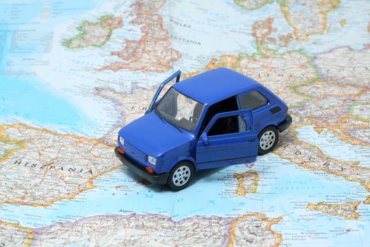 Tiny blue car model on the map of europe