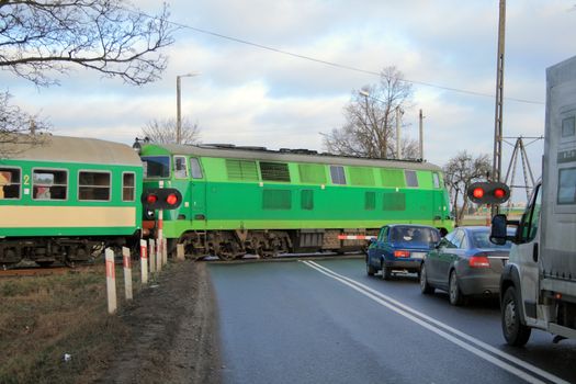 Passenger train passing the railroad crossing with the road