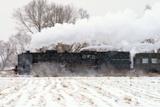 Old retro steam train starting passing through countryside
