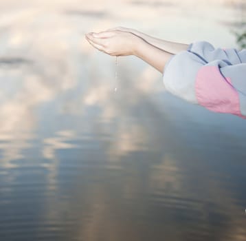 water drops in hands against the river