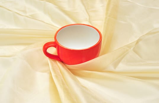 photo of single red cup at the golden fabric drapery 