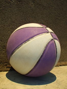 Close up of a basketball next to a wall.