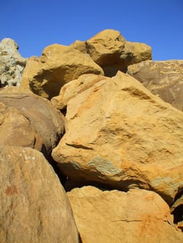 Close up of the boulders over clear blue sky.