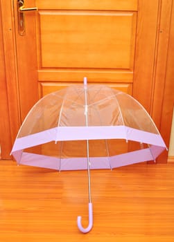 open transparent umbrella dries at home at door