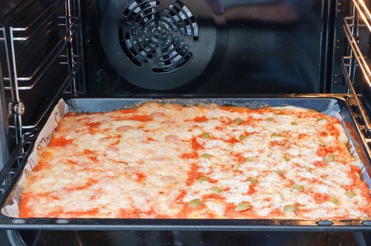 Delicious pizza is cooking in a kitchen oven 