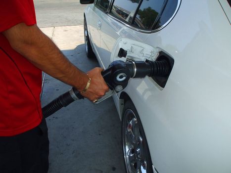 Close up of a person pumping gas.