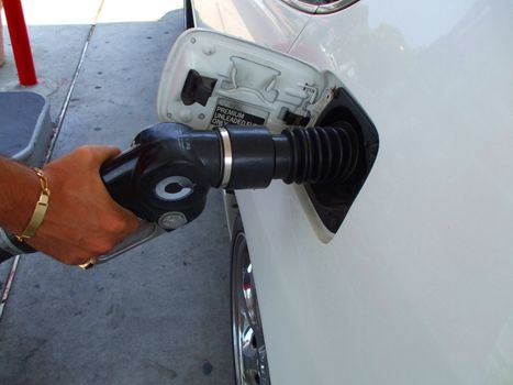 Close up of a person pumping gas.