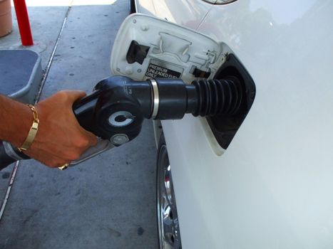 Close up of a person pumping gas.