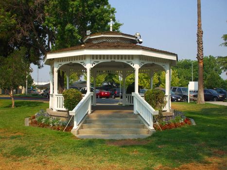 Close up of a white gazebo in a garden.