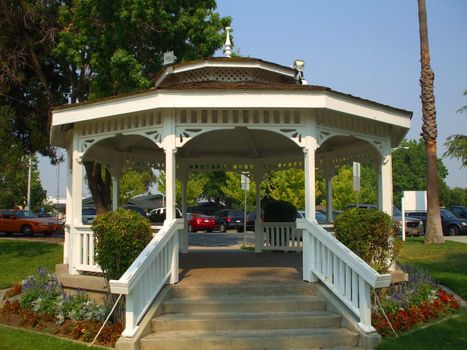 Close up of a white gazebo in a garden.