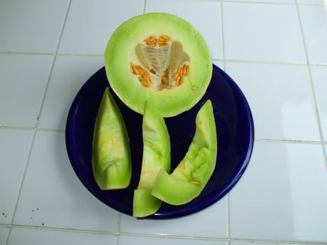 Close up of a honeydew melon on a plate.