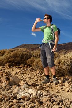 Hiker. Young man hiking / backpacking in very scenic and beautiful volcanic landscape on the volcano, Teide, Tenerife. 