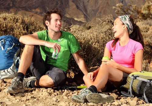 Couple having fun. Couple laughing during a break from hiking on a backpacking trip in the beautiful volcanic landscape. Location: The national park on the volcano, Teide, Tenerife, Spain. 