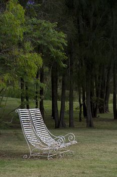 Two white wrought Iron chairs on lawn