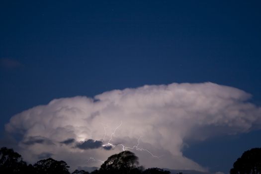 Storm cloud in the evening against a clear blue sky - lightning included