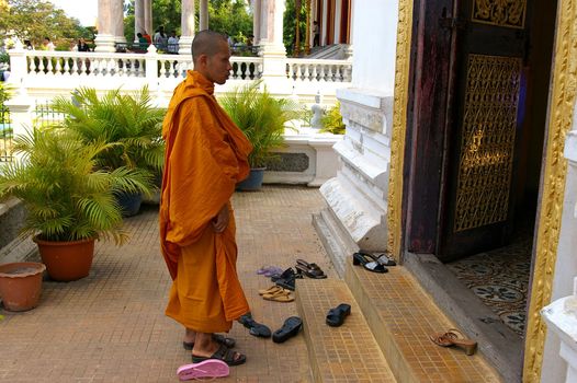 A Buddhist monk entering a place of worship at the Royal Palace, Phnom Penh, Cambodia. Most men become monks at sometime in their life, usually when young. The Monks of Cambodia still have a powerful influence in Cambodian society.