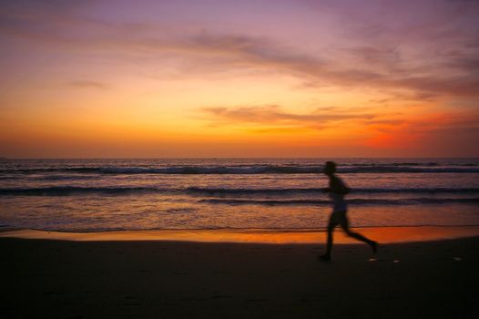 Jogging at sunset on Double Six beach, Seminyak, Bali, Indonesia.