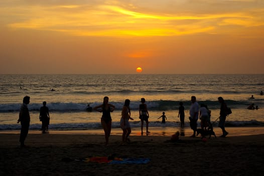 Crowded beach at sunset, Seminyak, Bali, Indonesia.