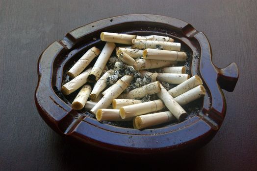 Cigarette stubs in an apple shaped ashtray.